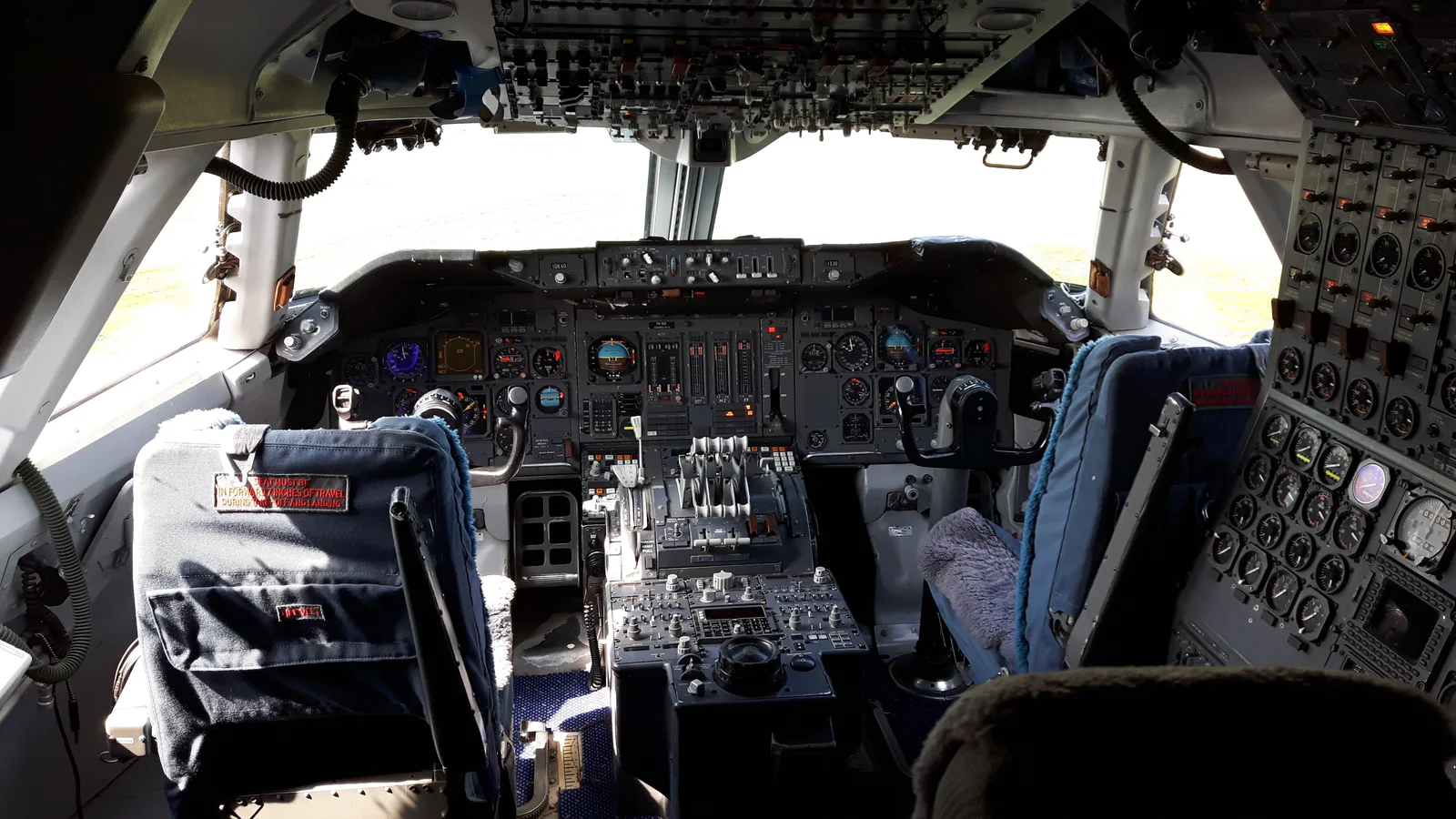 The cockpit of a Boeing 747-206, with controls covering the instrument panel, center console, overhead panel, and flight engineer’s station.