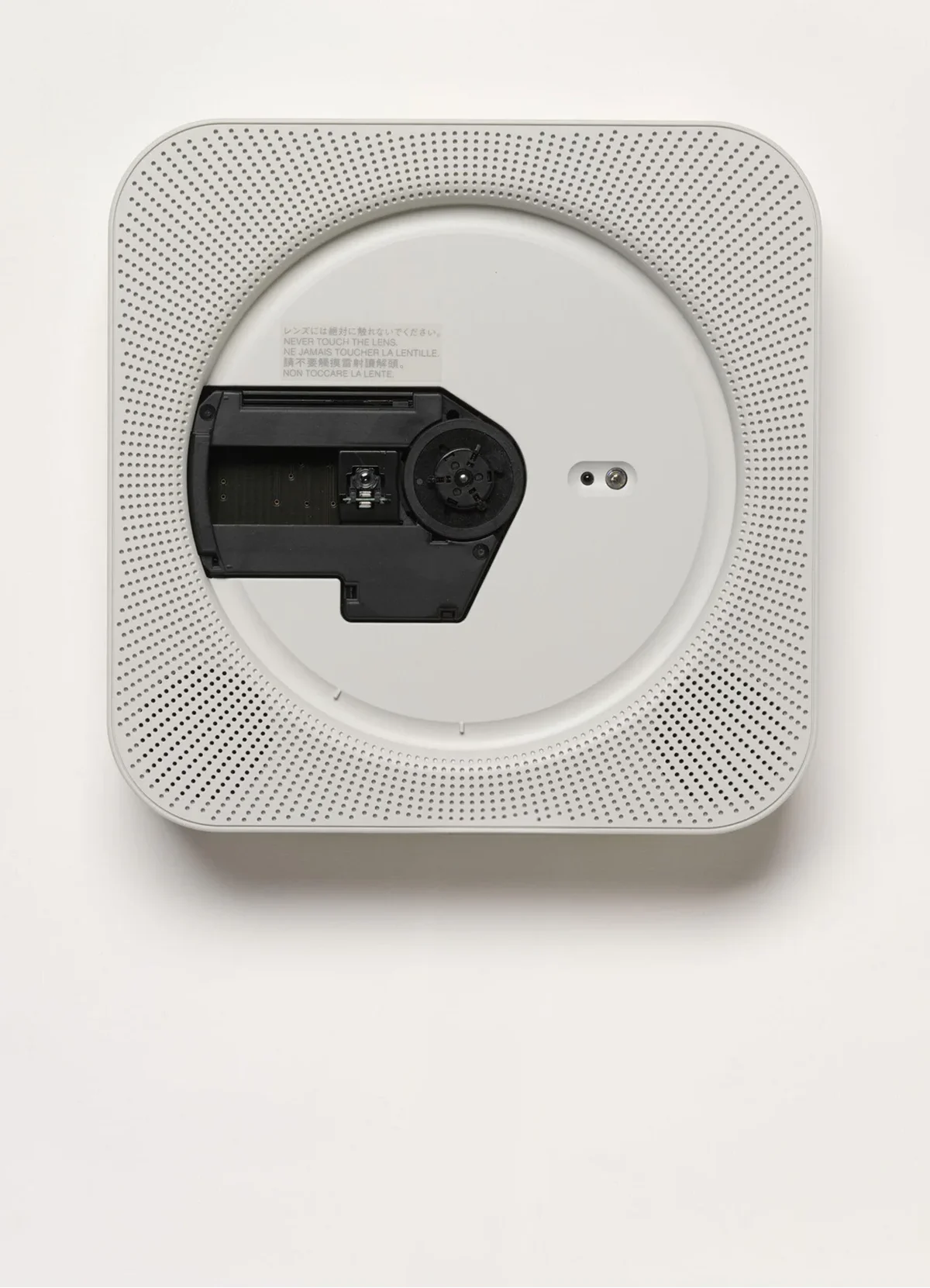 Naoto Fukasawa’s square white wall-mounted CD player for MUJI, with a circular open center, perforated speaker grille, and a single cord hanging below.